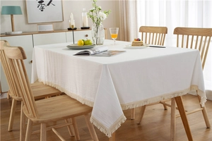 Detailaufnahme der weißen Baumwolltischdecke mit Naturstruktur und Fransenbordüre