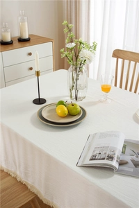 Detailaufnahme der cremeweißen Baumwolltischdecke mit eleganten Quasten und Naturstruktur