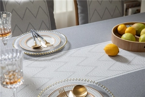 Detail of grey herringbone jacquard tablecloth with elegant wave fringe and tassels