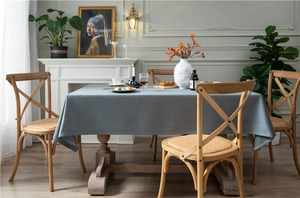 Detail of dark blue linen-textured tablecloth on wooden dining table in modern room
