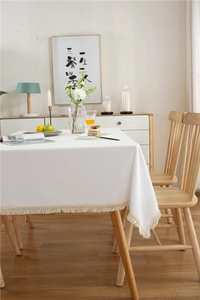 Nahaufnahme der modernen weißen Baumwolltischdecke mit elegantem Fransen-Saumdetail