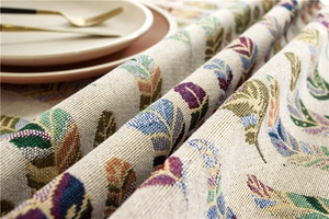 Close-up of woven jacquard tablecloth featuring colorful feather patterns and textures
