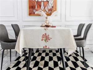 Detailed embroidery of pink blossoms on beige linen rectangle tablecloth with finished edges