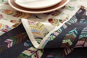 Macro detail of bohemian jacquard tablecloth showing colorful feather patterns and weave