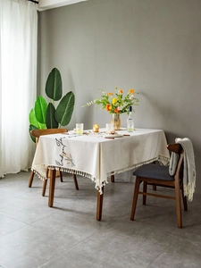 Detail of embroidered floral pattern and Enjoy your life text on linen tablecloth fringe