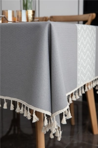 Macro detail of wave pattern jacquard fabric and decorative off-white fringe on tablecloth