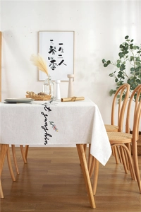 Detail of floral and letter embroidery on beige cotton linen rectangular tablecloth