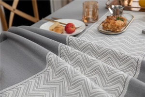 Detail of grey and white chevron jacquard tablecloth with textured weave and premium sewing