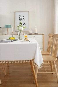 Detailaufnahme einer weißen Tischdecke aus gewaschener Baumwolle mit eleganten Fransen