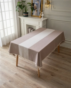 Macro shot of rectangular pink jacquard tablecloth with beige geometric fringe details