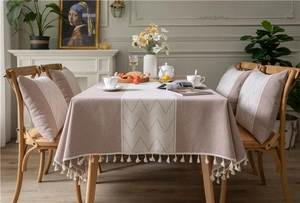 Detail of warm coffee herringbone jacquard tablecloth with elegant tassel fringe edges