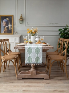 Detail of chenille table runner with green leaf patterns and blue beaded fringe