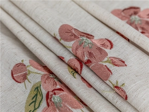 Detailed embroidery of pink blossoms on cream linen fabric for rectangular tablecloths