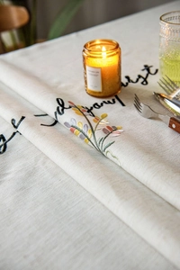 Close-up of floral embroidery and calligraphy on rectangular cotton linen tablecloth