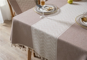 Detail of bohemian jacquard tablecloth featuring fringe tassels and herringbone texture