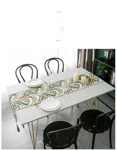 Detail of colorful leaf pattern table runner with tassels and elegant place setting