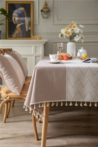Detail view of jacquard geometric pattern and white fringe on a minimalist table runner