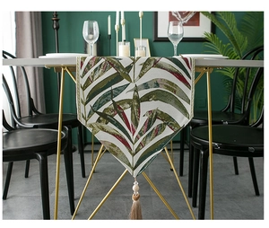 Detail of chenille table runner with leaf pattern and elegant hanging tassel fringe
