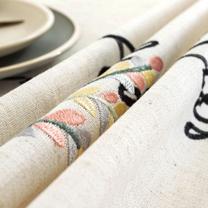 Embroidered linen tablecloth with elegant floral patterns and cursive script design