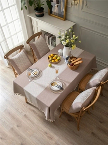 Close-up of textured jacquard tablecloth with chevron pattern trim and fringe detail