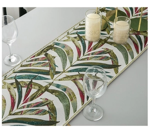 Macro detail of tropical leaf chenille table runner with fringe on a modern table
