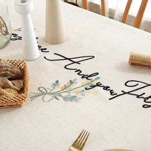 Linen floral embroidered tablecloth with elegant green leaves and cursive script