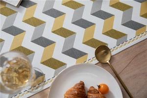 Close-up of jacquard chenille table runner with geometric chevron pattern and tassels