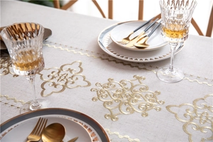 Close-up of golden vintage cloud embroidery on beige cotton linen luxury tablecloth