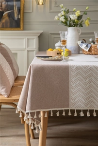 Detail of Morandi pink jacquard tablecloth featuring white geometric patterns and cotton tassels