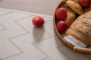Detailed view of beige woven table runner with herringbone pattern and textured tassels