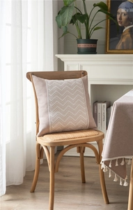 Close-up of the elegant jacquard weave pattern and tassels on a pink tablecloth