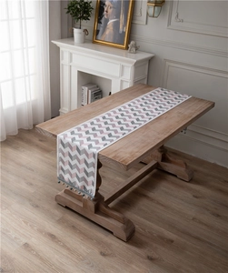 Detail of jacquard chenille table runner with zigzag pattern and beaded fringe accents