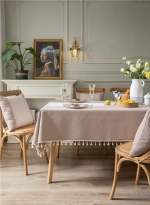 Detail of dusty pink tablecloth featuring elegant white tassels and geometric wave texture