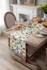 Close-up of chenille table runner with leaf pattern and blue tassel fringe detail
