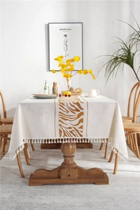 Detail of bohemian rectangle tablecloth with brown zebra pattern and white tassel fringe