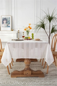 Detail of white cotton lace tablecloth showing vertical hollow embroidery and fringe edges