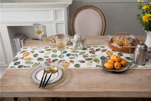 Lifestyle view of a chenille table runner with colorful leaf patterns on a wooden table