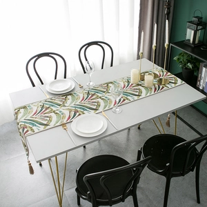 Chenille table runner with colorful tropical leaf pattern and elegant beige tassels
