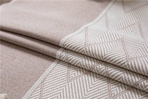 Detailed view of jacquard woven geometric diamond pattern with wavy fringe tassels