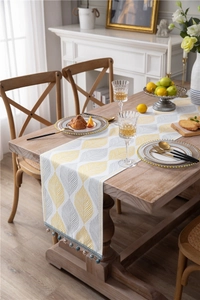 Detail of yellow leaf jacquard chenille table runner with beaded fringe and tassels