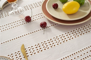 Close-up of French lace tablecloth featuring cotton hollow embroidery and geometric cutouts