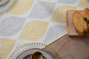 Macro detail of leaf pattern on chenille table runner with modern yellow and grey jacquard texture