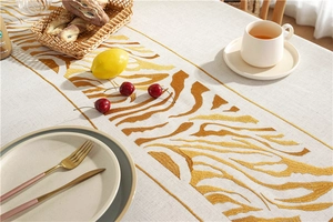 Detail of embroidered wavy stripes on beige linen tablecloth with rustic decor items