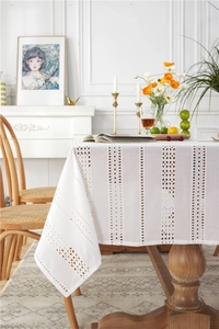 Detailed view of white cotton lace tablecloth with floral embroidery and hollow out design