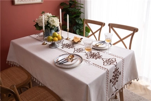 Close-up of bohemian geometric patterns and beige tassels on cotton linen tablecloth