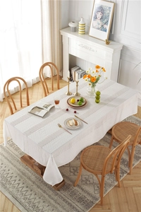 Close-up of white French country lace tablecloth with hollow crochet and fringe details
