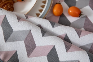Detail of jacquard chenille table runner featuring textured chevron patterns and tassels