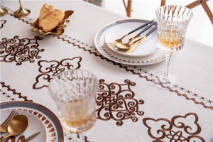 Close-up of vintage floral embroidery and fringe details on linen table runner