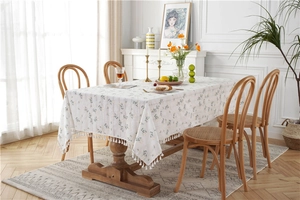 Detailed macro view of cotton floral tablecloth with white pompom tassel fringe decor