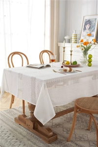 Close-up of white lace tablecloth with hollow embroidery and vintage floral mesh patterns